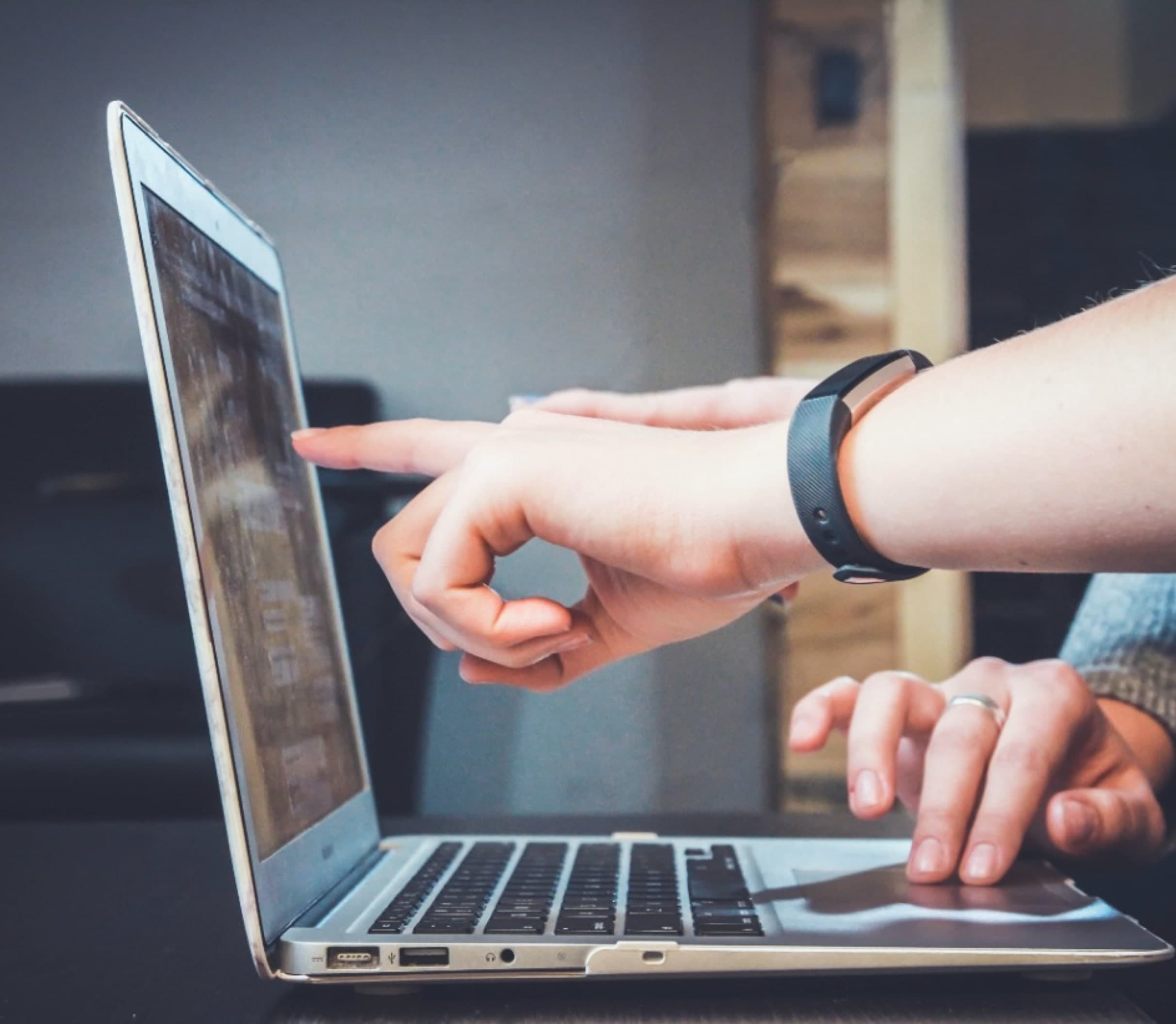 Hands Pointing to a Laptop